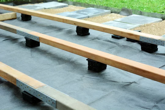 Unterkonstruktion für Terrasse mit Holzbalken, Terrassenpads aus