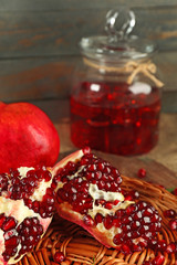 Pomegranate seeds and juice on wicker tray, closeup