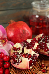 Pomegranate seeds and juice on wicker tray, closeup
