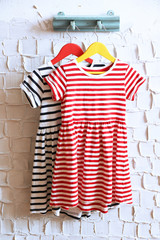 Child dress on hanger on white wall background
