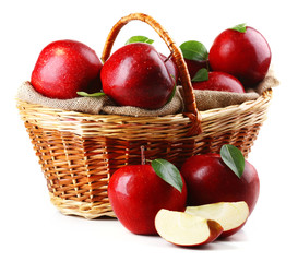 Red apples in wicker basket isolate on white