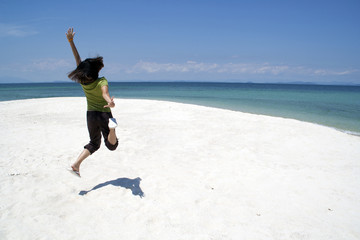 The young asian black hair woman jumping at the mun nok island beach on sunny day. 