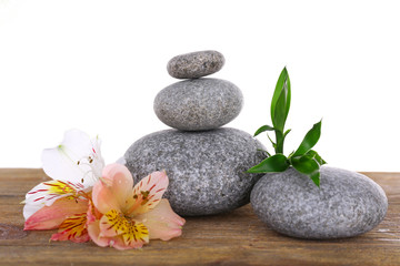 Obraz na płótnie Canvas Stack of spa stones with flower isolated on white