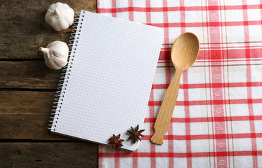 Open recipe book on napkin, on wooden background