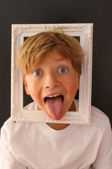Young child with his head inside a picture frame