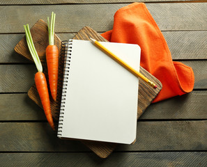Open recipe book, vegetables on wooden background