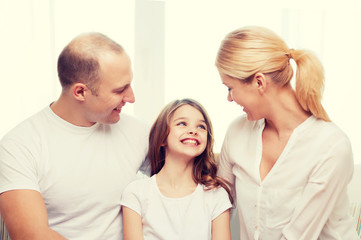 smiling parents and little girl at home
