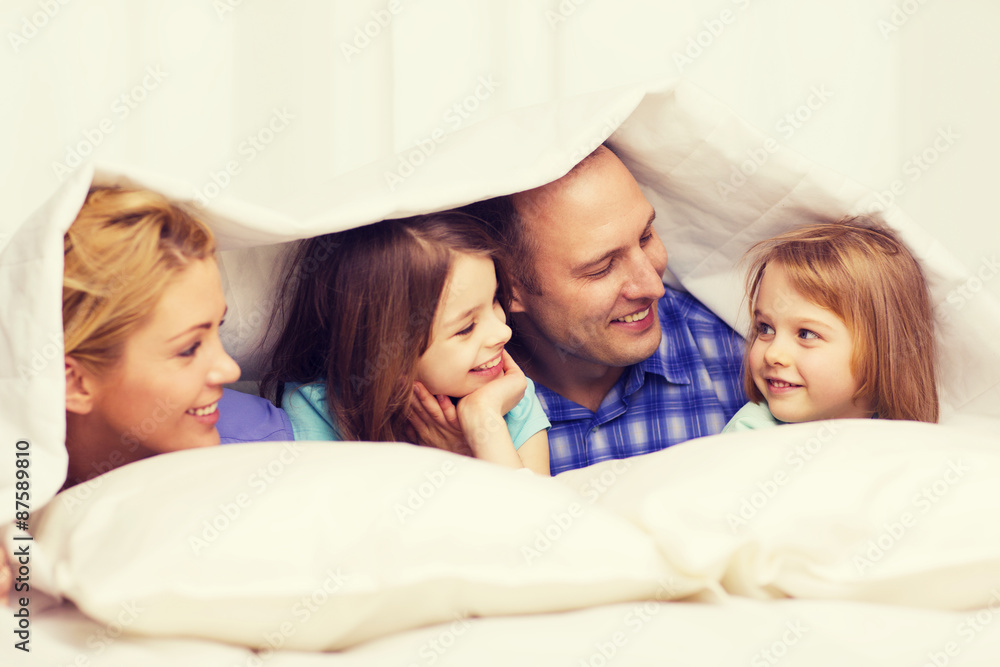 Wall mural happy family with two kids under blanket at home