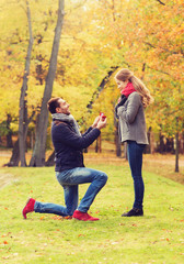 smiling couple with engagement ring in gift box