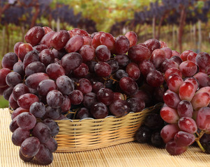 Some red grapes in a wooden pot over a wooden surface seen from