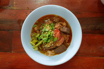 Rice noodles mix with spicy pork sauce serve in blue bowl 