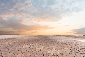 Naklejka premium Soil drought cracked landscape sunset