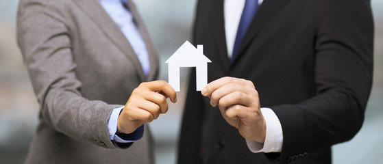 businessman and businesswoman holding white house