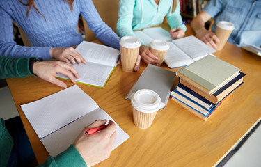 close up of hands with books writing to notebooks