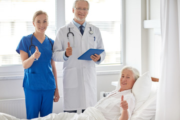 doctor and nurse visiting senior woman at hospital