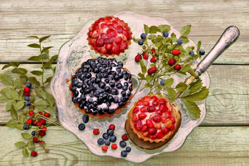 Plate with berries cake on wooden background