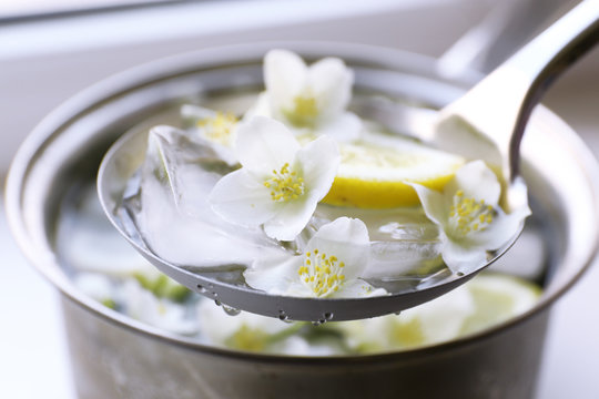 Cold refreshing summer drink with mint and slices of lemon in pan close up