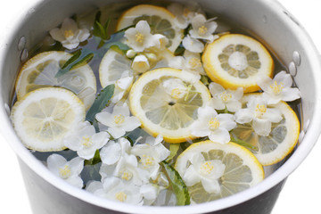 Cold refreshing summer drink with mint and slices of lemon in pan close up