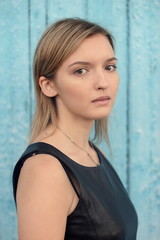 Fototapeta premium Young shy blonde brown-eyed girl with long straight hair in blac