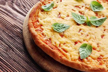 Cheese pizza with basil on table close up