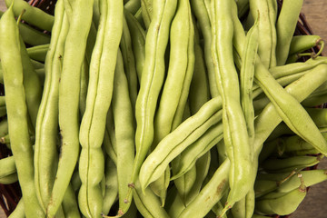 small and slender green beans (haricot vert) on a wood