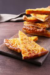 Slices of tasty cheese on table close up