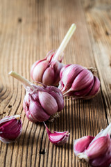 Organic raw purple garlic on wooden background