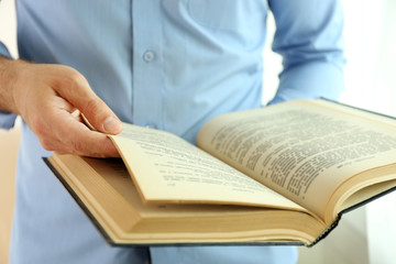 Young man reading book close up