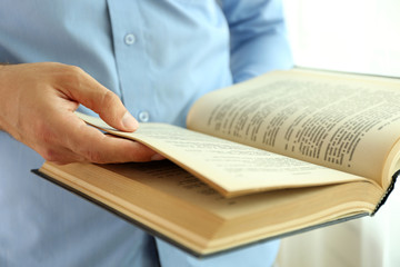 Young man reading book close up