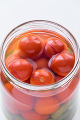 Open jar with pickled cherry tomatoes