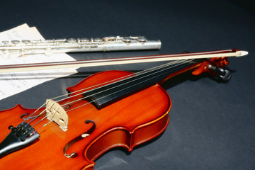 Fototapeta premium Violin and flute with music notes on dark background