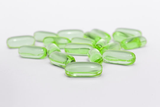 green gel capsules / vitamin c pills / fish oil , isolated on white background