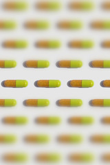 many pills / capsules symmetric pattern isolated on white
