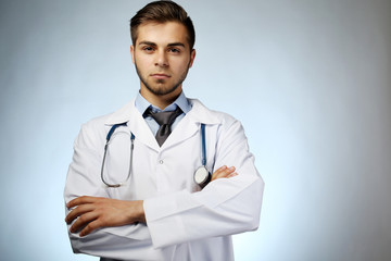 Male doctor with stethoscope on blue background