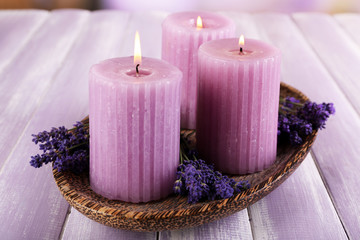 Candles with lavender flowers on table close up