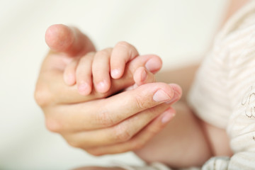 Obraz na płótnie Canvas Adult and baby hands, closeup