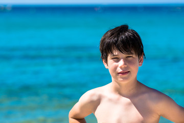 Young boy playing at sea, blue sea background