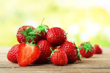 Ripe strawberries on wooden table on blurred background