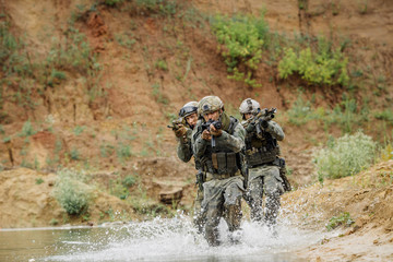 Military team crossing the river under fire