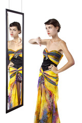 woman wearing a dress with her thumbs down while looking at a mirror