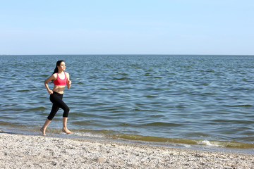 Young woman jogging on beach