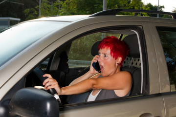 erschrocken, schockierte Frau beim Autofahren mit Handy am Ohr