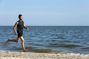 Young man jogging on beach