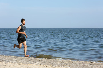 Fototapeta na wymiar Young man jogging on beach
