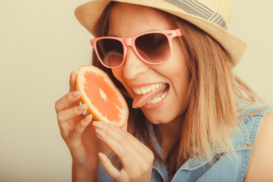 Happy woman in hat drinking grapefruit juice. Diet