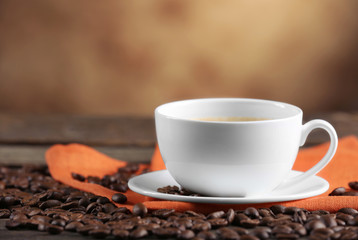 Cup of coffee and beans on blurred background