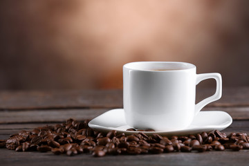 Cup of coffee and beans on blurred background