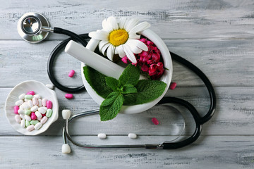 Obraz na płótnie Canvas Alternative medicine herbs and stethoscope on wooden table background