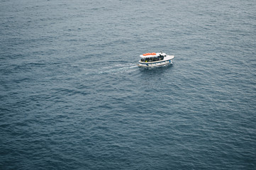 Fototapeta premium Sightseeing ferry boat traveling across wide blue ocean background in the Mediterranean Sea