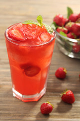 Glasses of strawberry juice with berries on table close up